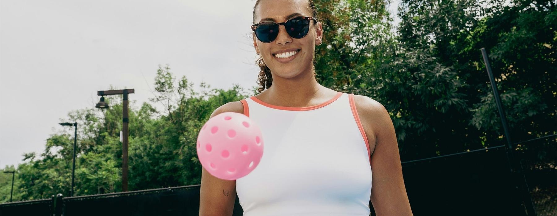 a woman holding a paddle and a ball